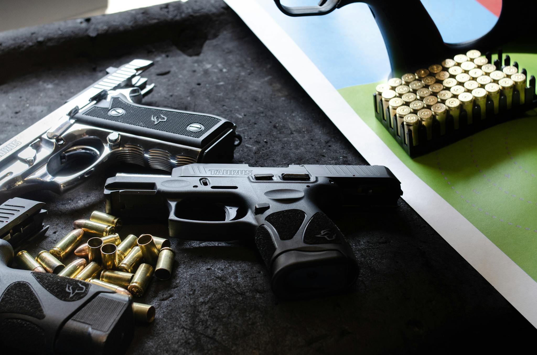 Close-up of guns and ammunition on a table, highlighting safety and weaponry themes.